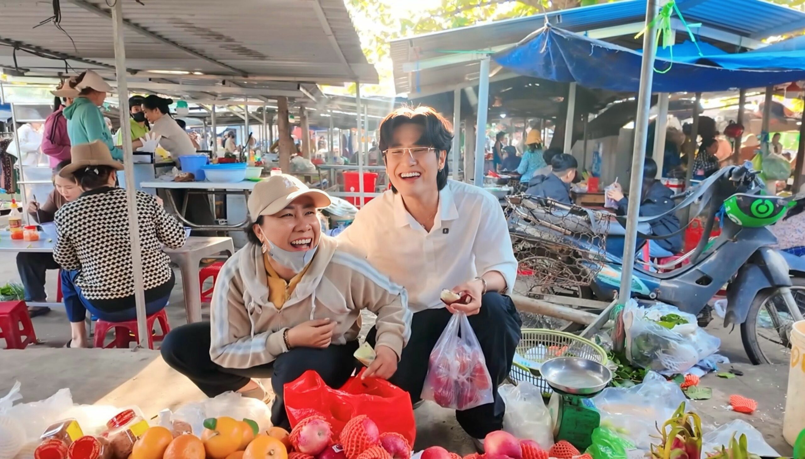 TikToker Quan Không Gờ chụp ảnh cùng tiểu thương tại một ngôi chợ truyền thống Việt Nam.